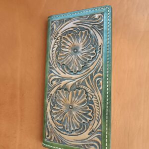 Compagnon en cuir artisanal bicolore vert et marron avec motifs floraux et géométriques ciselés à la main.