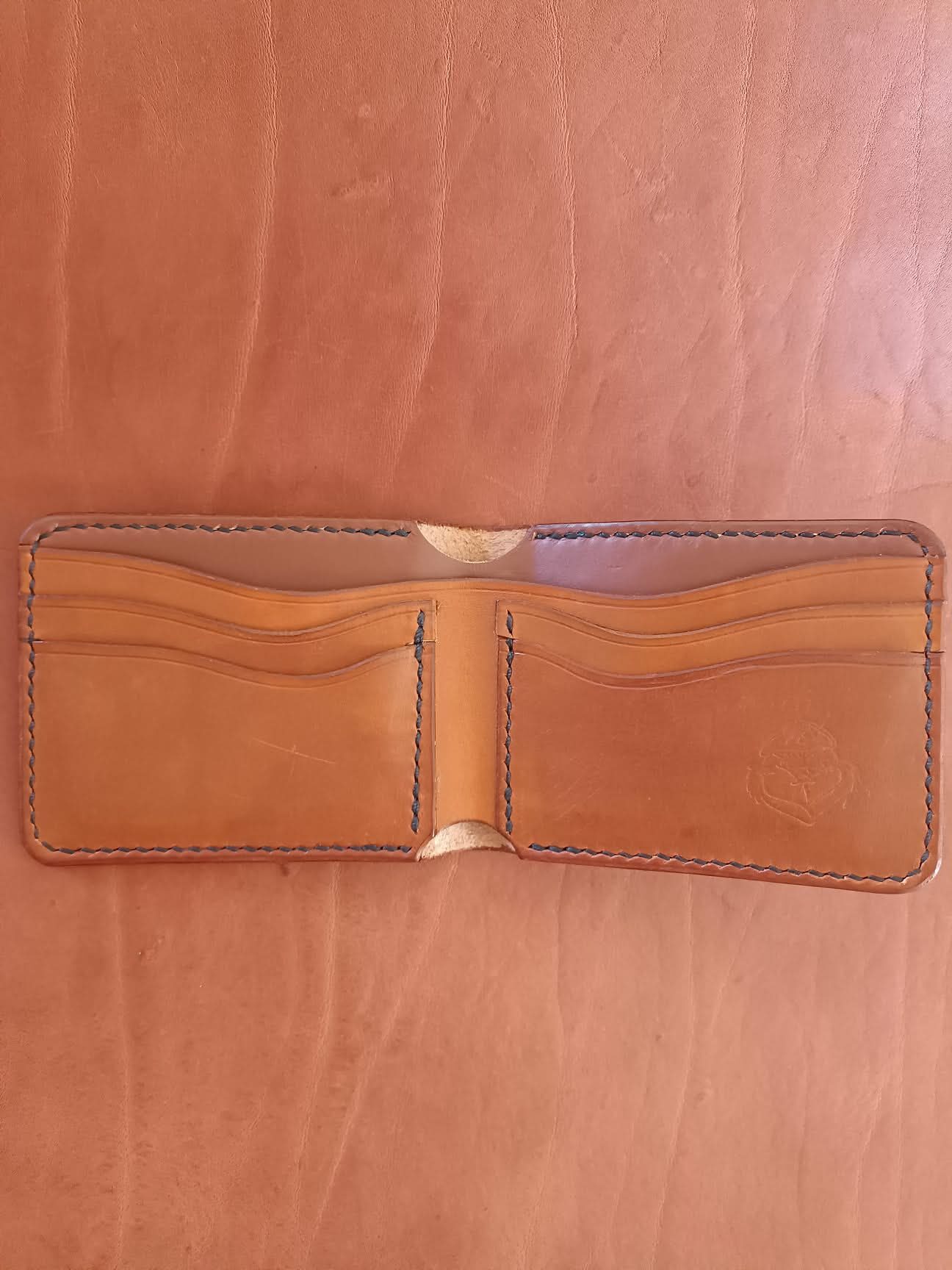 Intérieur d'un portefeuille en cuir fauve artisanal montrant les fentes pour cartes et le logo Grinch Factory