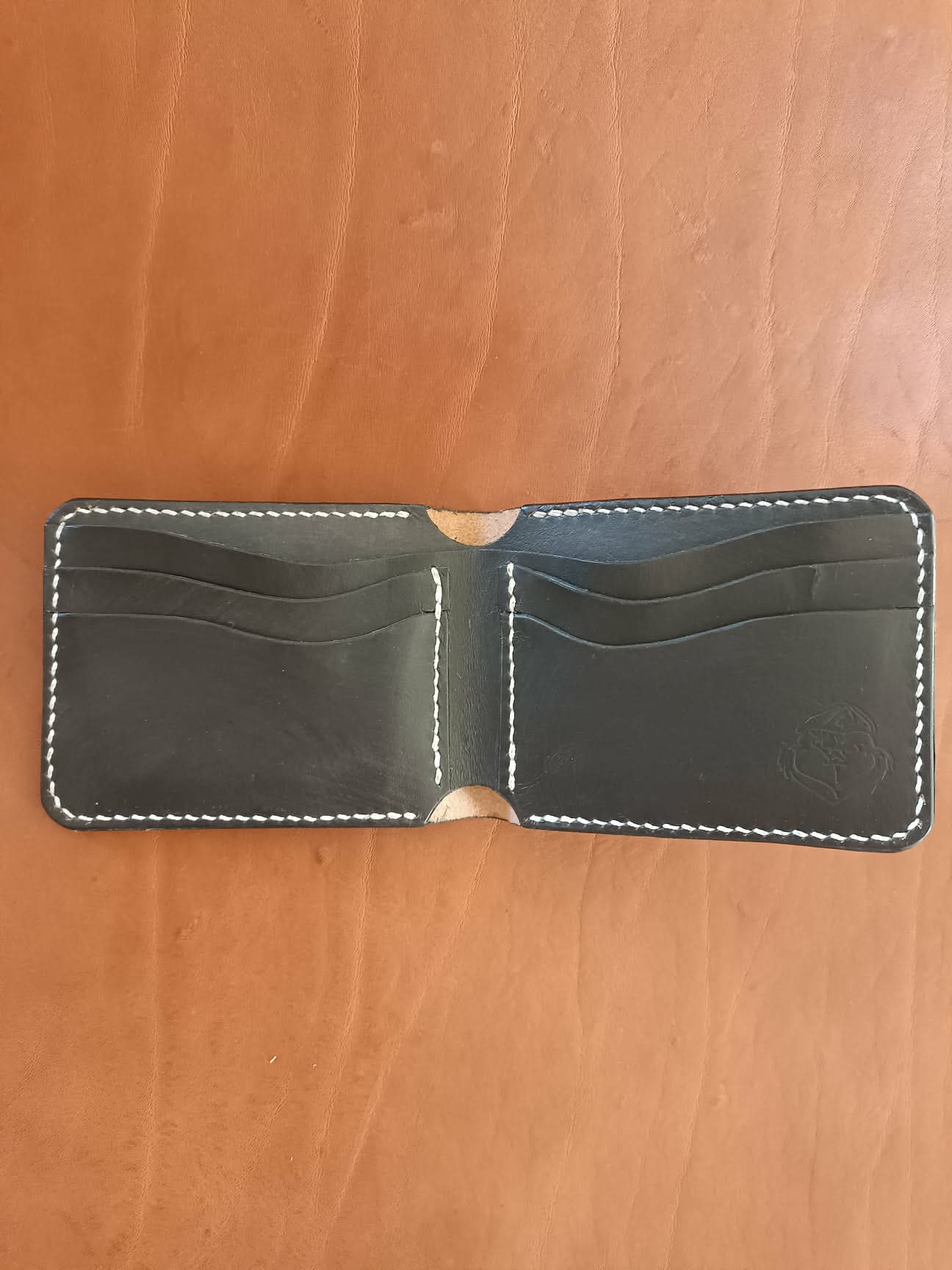 Intérieur d'un portefeuille en cuir noir artisanal montrant les fentes pour cartes et le logo Grinch Factory