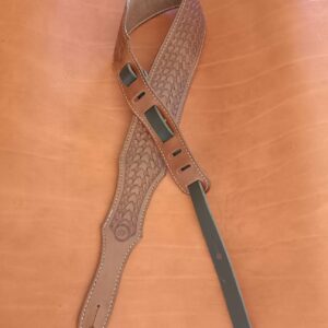 Sangle de guitare en cuir marron clair avec motif tressé Basket Weave, épaulière large et coutures blanches sur fond de cuir naturel