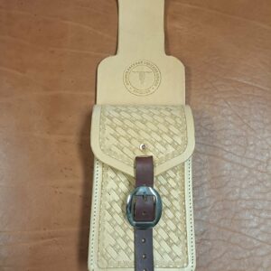 Sacoche en cuir beige avec motifs repoussés à la main (tooling basketweave) fixée sur un passant de sangle arrière western, fermeture par boucle en cuir marron et boucle chromée, logo Grinch Factory.