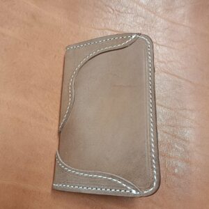 Porte-carte bifold en cuir marron avec coutures blanches et logo Grinch Factory, artisanat français.